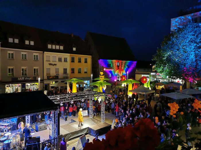 Viele Besucher verfolgen die Modenchau auf dem illuminierten Marktplatz. 
