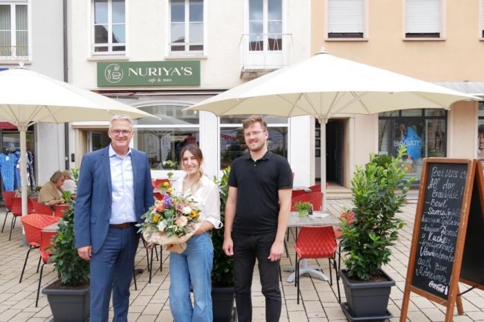 OB Steffen Hertwig, Inhaberin Nuriya Haitkulova und Citymanager Daniel Bürkle stehen vor dem neuen Cafe am Marktplatz.