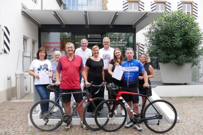 Die Gruppe der Preisträger mit OB Hertwig und zwei Fahrrädern vor dem Zweiradmuseum  