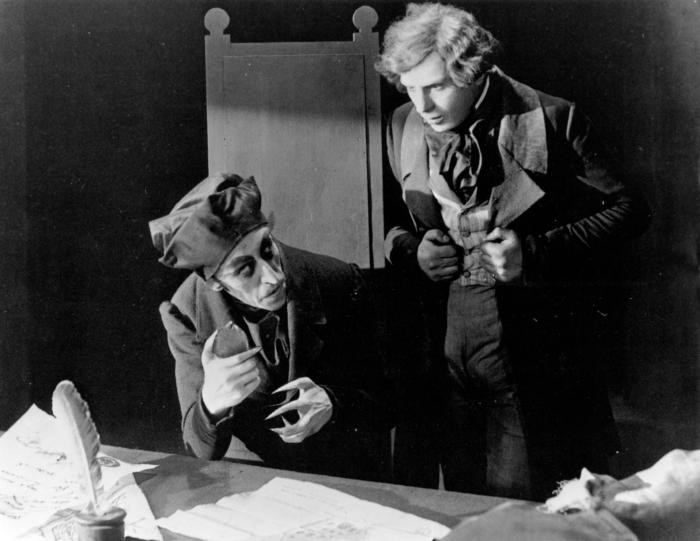 In einer Filmszene sitzt Graf Orlok am Schreibtisch und Jonathan Hutter steht neben ihm.