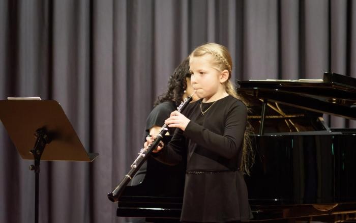 Nelly Haug steht auf der Bühne und spielt Oboe. 