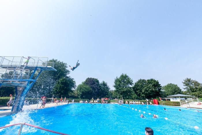 Foto: Joachim Schmitt Ein Badegast springt vom Turm ins Freibadbadbecken.