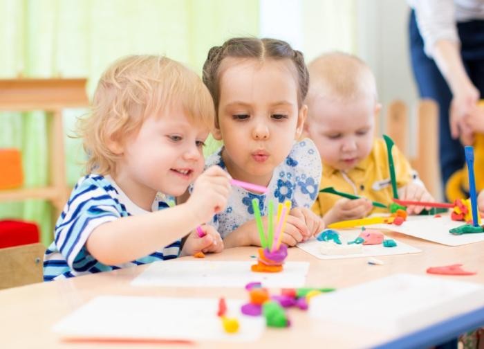 Kinder spielen mit Buntstiften. 