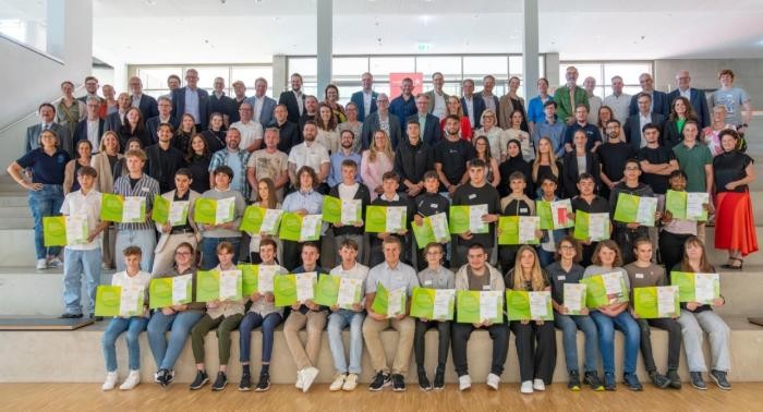 Gruppenbild der Preisträger und Partner des Wettbewerbs in der Mensa der Franz-Binder-Verbundschule  