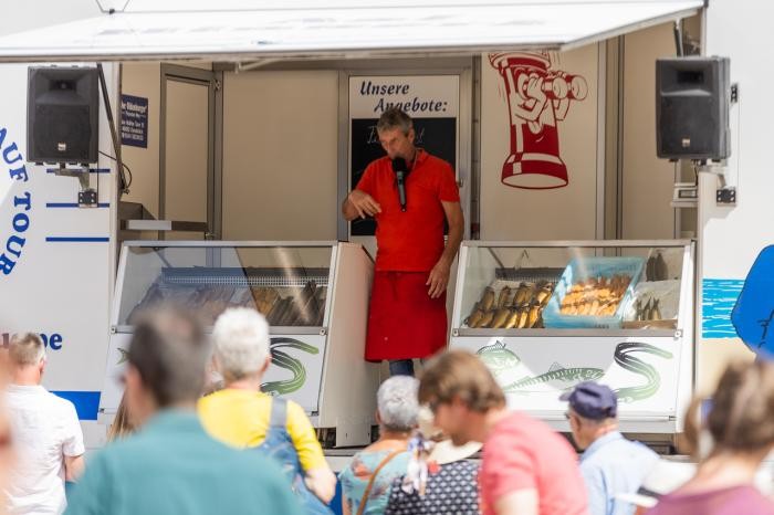 Aal-Hinnerk steht in seinem Verkaufswagen und spricht zu den Kunden. Foto: Daniel Nasse