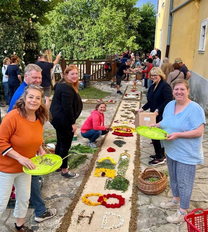 Traditionelles Auslegen eines Blumenteppichs zu Fronleichnam Die Delegation aus Neckarsulm legt Blumen nieder, um daraus einen Blumenteppich herzustellen.