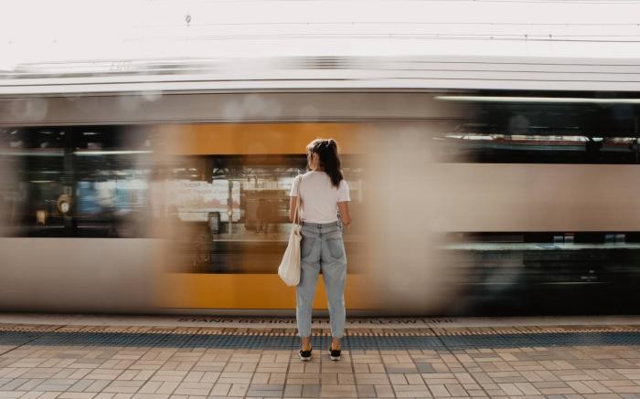 Frau vor einer vorbeifahrenden S-Bahn