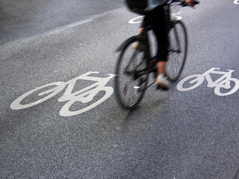 Ein Radfahrer fährt über einen mit Piktogrammen gekennzeichneten Radweg. 