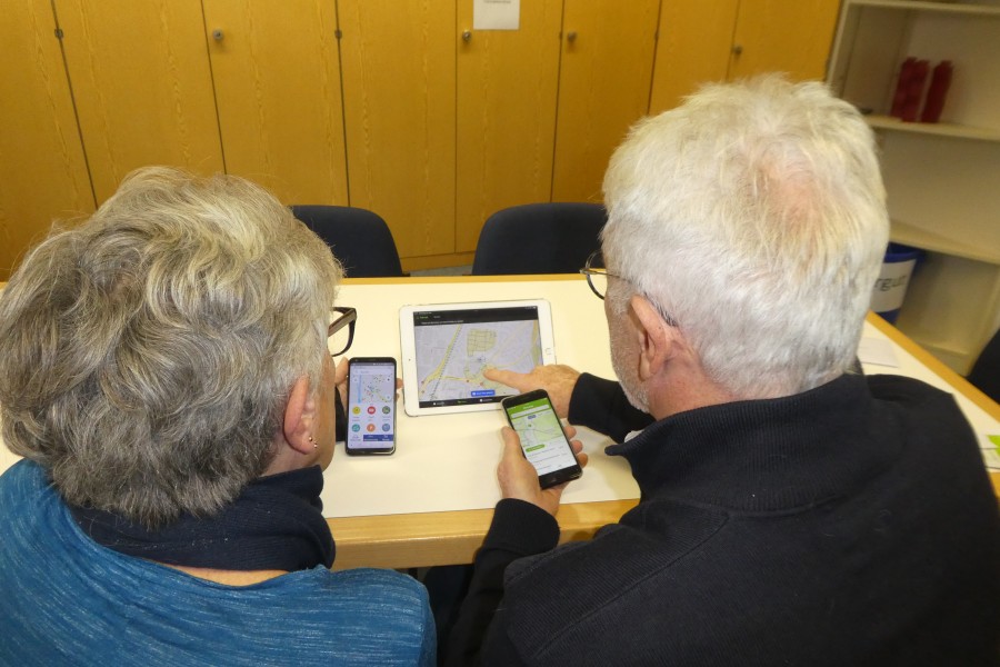 Zwei Senioren sitzen vor einem Tablet. 