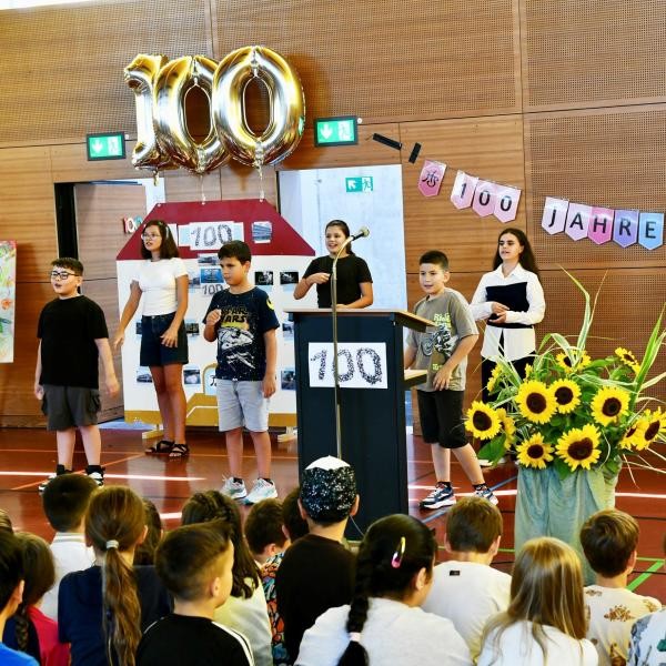 Schülerinnen und Schüler beim Jubiläumsfestakt in der festlich geschmückten Schulsporthalle