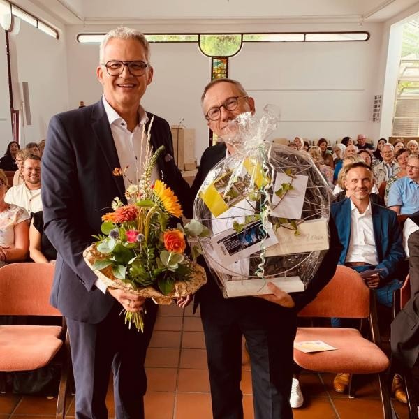 OB Steffen Hertwig verabschiedet Hans Peter Brugger mit Blumenstrauß und Geschenkkorb.