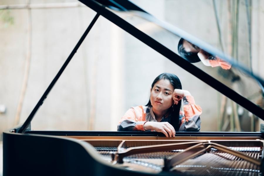 Die Pianistin Yu Kosuga sitzt hinter dem Piano.