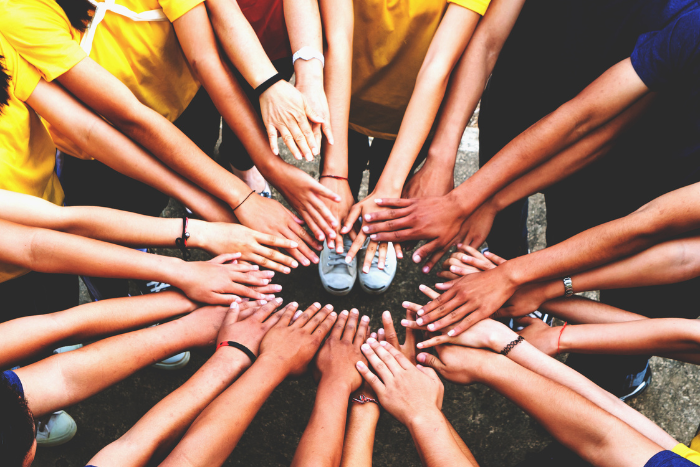 Hände treffen sich in der Mitte.