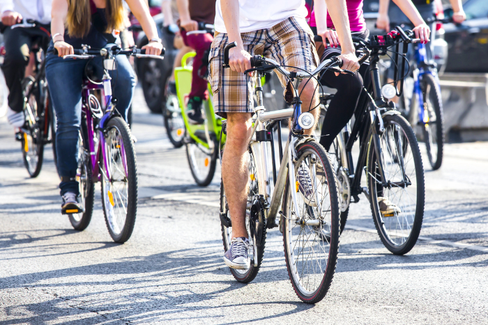 Viele Fahrräder fahren auf einer asphaltierten Straße.